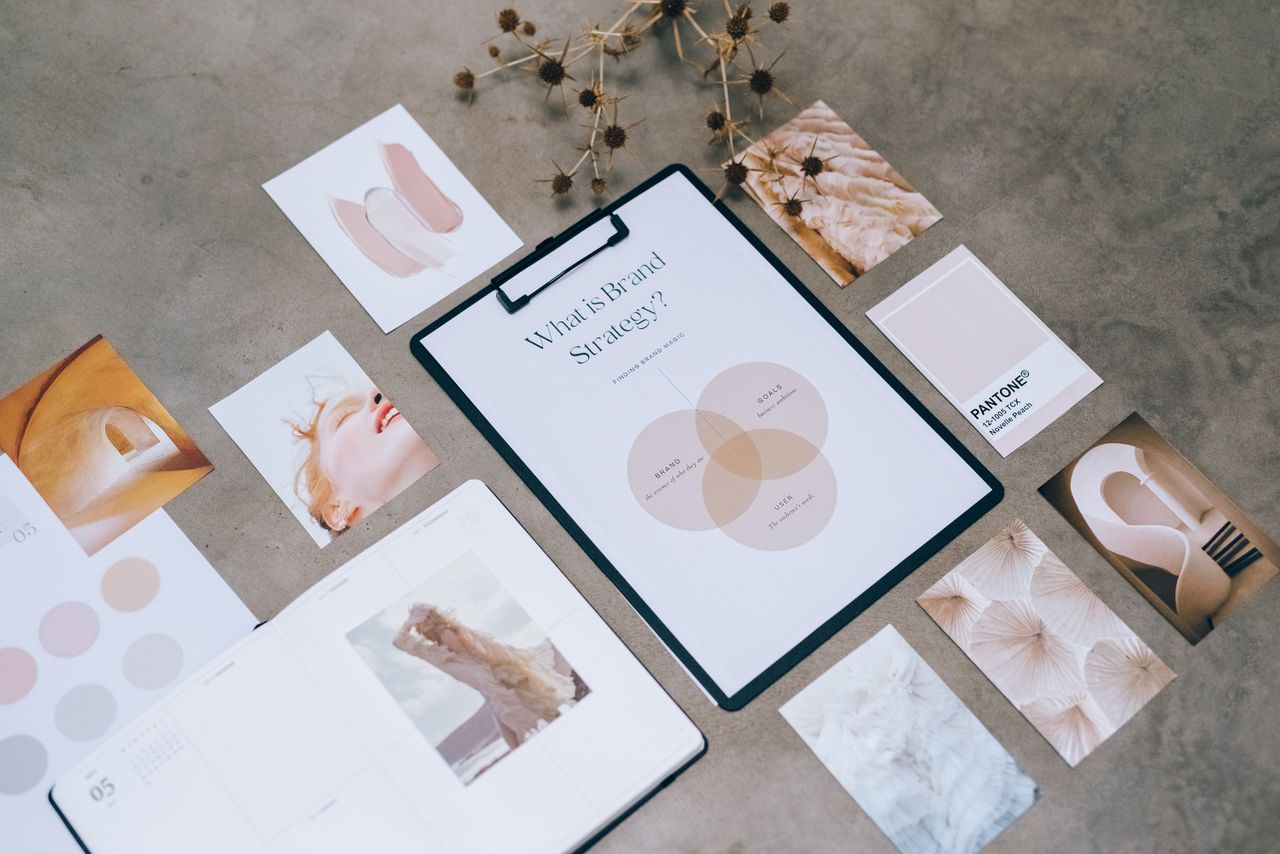 A flat lay of a minimalist brand strategy mood board on a concrete surface.